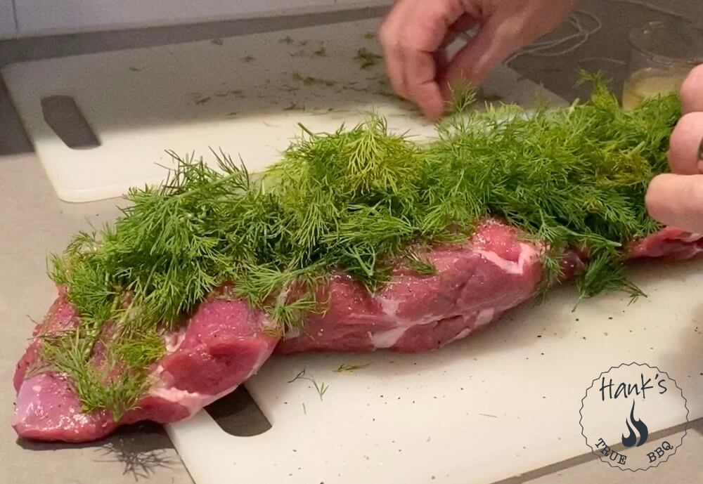 Lamb roast being stuffed with dill