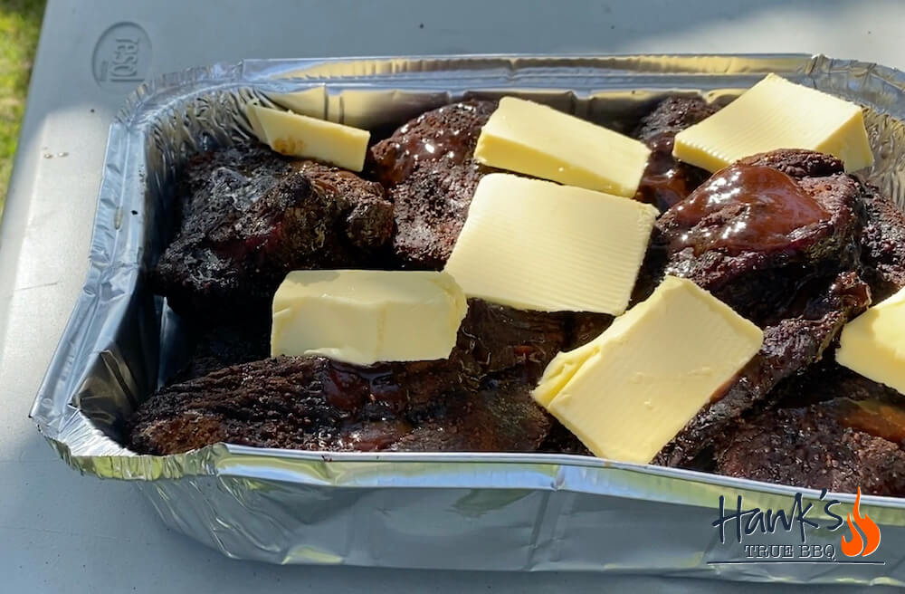 Beef cheeks with butter in a disposable pan